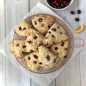 Top down view of lemon cranberry scones arranged on a rack.