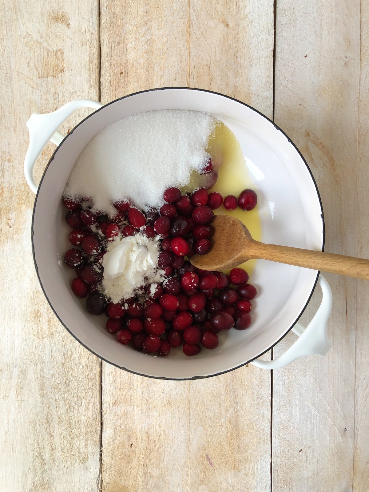 Hot cranberry jam filling cooked in saucepan.