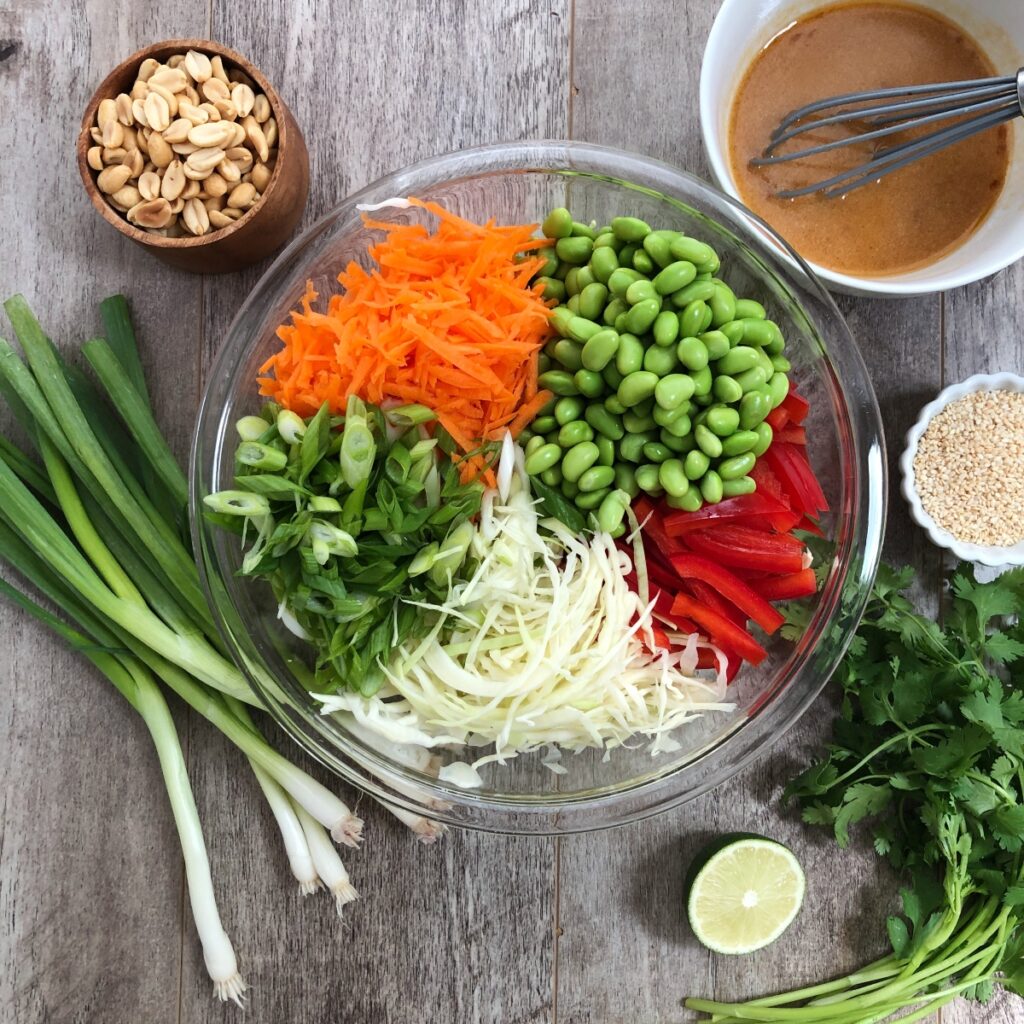 Salad ingredients assembled in a glass mixing bowl.